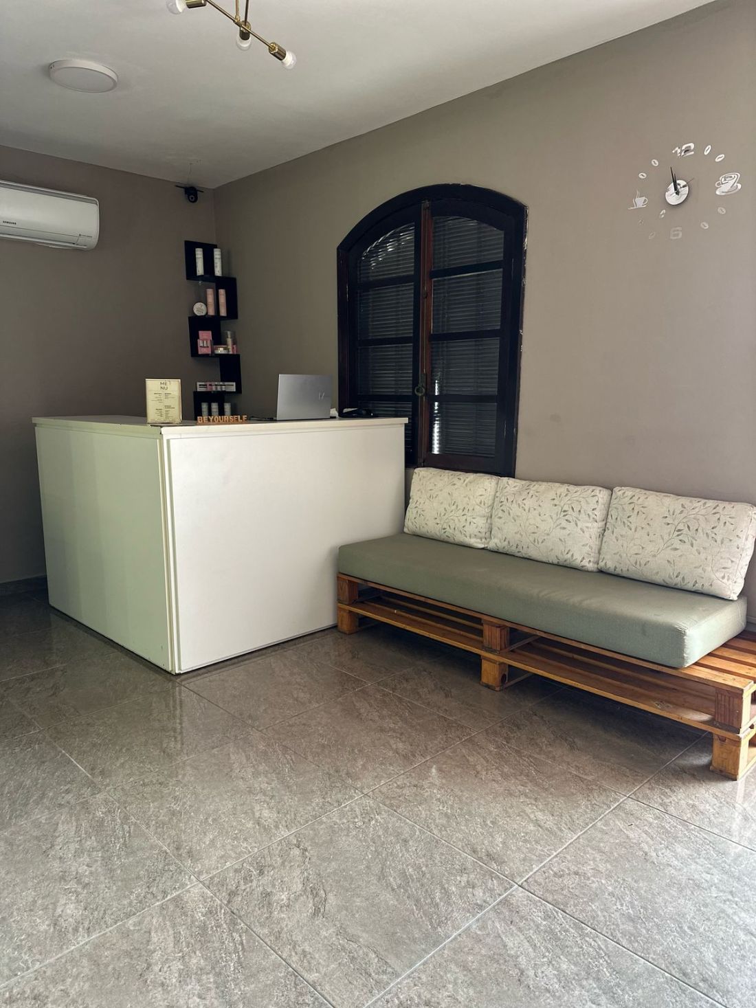 A recepção, com o balcão branco e o sofá – Be Yourself, São Sebastião